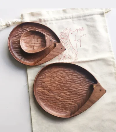 A set of walnut wood plates shaped like a family of hedgehogs