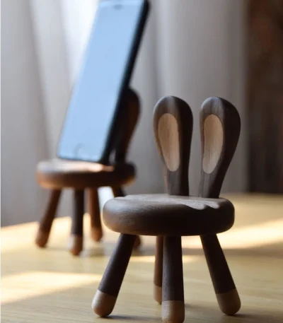 A wooden phone stand with bunny ears, perfect as a gift