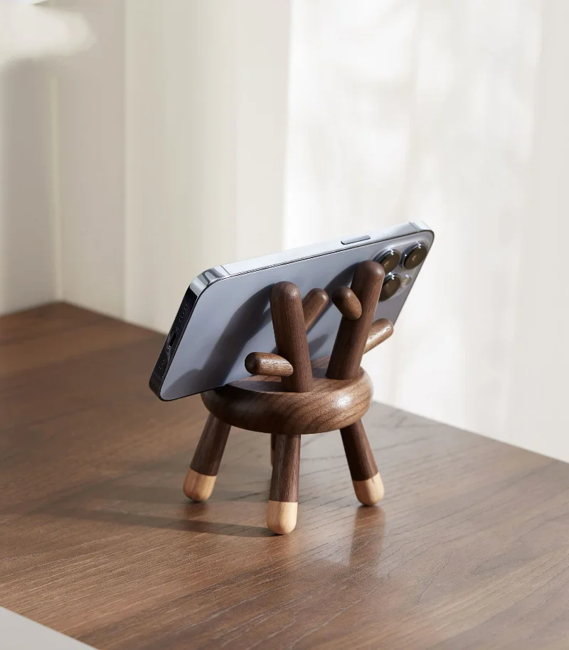 A wooden phone holder featuring deer antlers