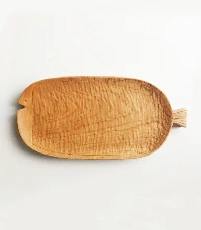 A long wooden plate made of cherry wood, shaped like a fish