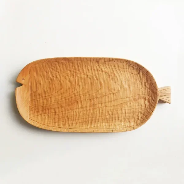 A long wooden plate made of cherry wood, shaped like a fish