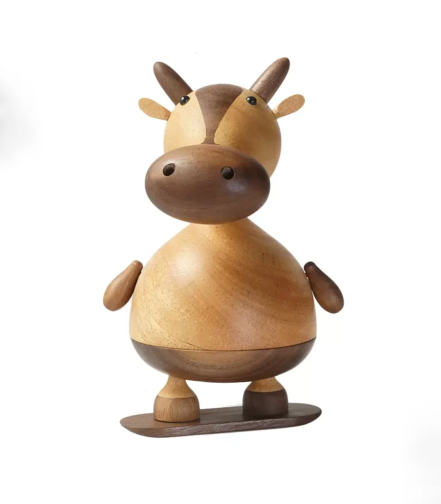 A whimsical wooden music box featuring a cow on a skateboard