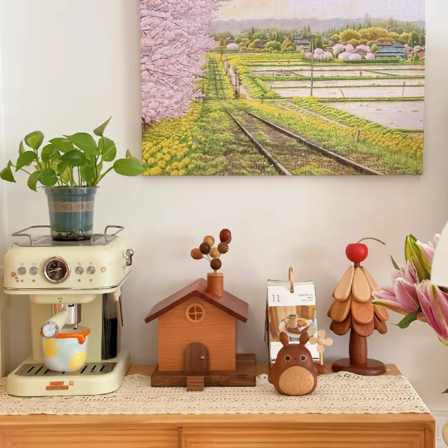 A set of three wooden decor items including a balloon house and a Christmas tree coaster