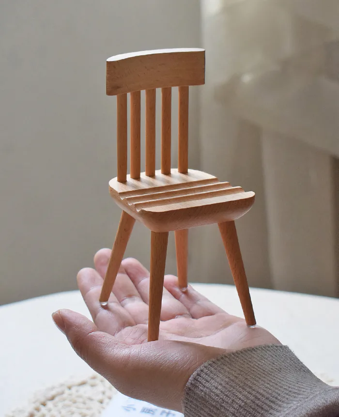 Wooden phone holder designed like a chair, perfect for organizing and decorating your desk