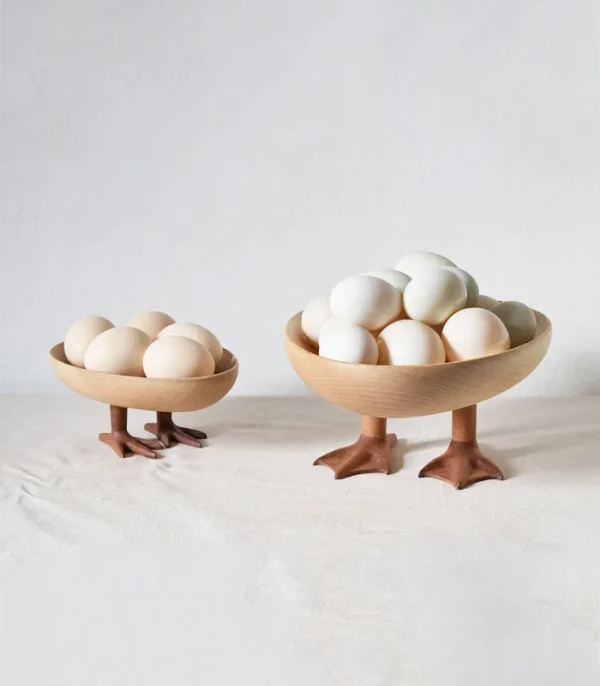 A whimsical wooden pedestal tray, supported by goose feet, ideal for serving or displaying