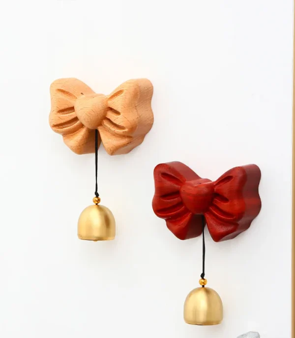A wooden doorbell featuring a heart and bow design