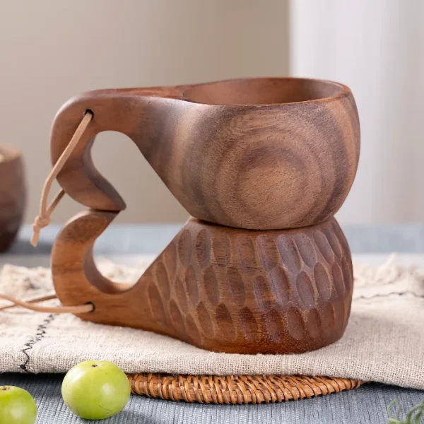 A beautifully handcrafted wooden kuksa cup featuring an elegant elephant trunk-shaped handle