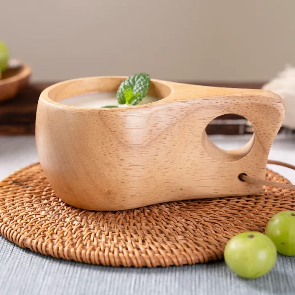 Handcrafted wood kuksa cup featuring a round hole handle, perfect for tea, coffee, or outdoor use